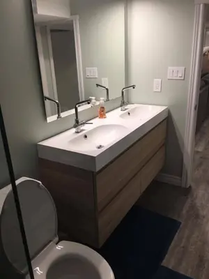 a bathroom with a sink and a toilet and a mirror at Upscale 2-Bedroom Basement Apartment in London