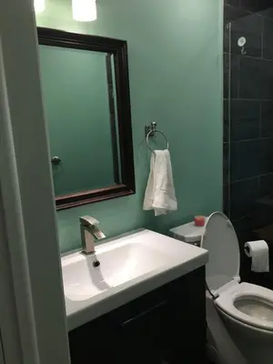 a bathroom with a sink and a toilet and a mirror at Comfy 3-Bedroom Home with Modern Upgrades in London