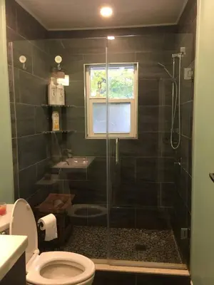 a bathroom with a shower with a toilet and a sink at Comfy 3-Bedroom Home with Modern Upgrades in London