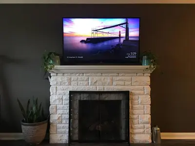 a flat screen tv sitting on top of a fireplace at Comfy 3-Bedroom Home with Modern Upgrades in London