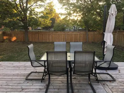 a table and chairs and an umbrella on a patio at Comfy 3-Bedroom Home with Modern Upgrades in London