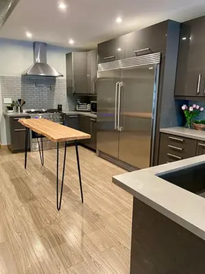 a kitchen with a wooden table and a refrigerator at Stylish Modern 2 bedroom house across from Beach in Hamilton