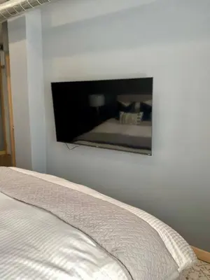 a bedroom with a flat screen tv on the wall at Stylish Modern 2 bedroom house across from Beach in Hamilton