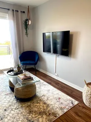 a living room with a flat screen tv on the wall at Beautiful Renovated Beach Cottage Home in Hamilton