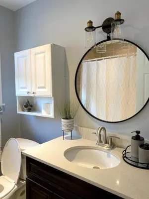 a bathroom with a sink and a toilet and a mirror at Beautiful Renovated Beach Cottage Home in Hamilton