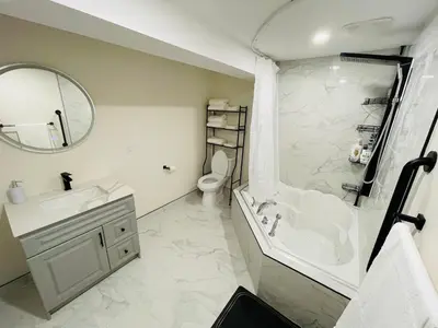 a bathroom with a sink and a tub and a toilet at Modern Thorold Apt with Pool Table in Thorold