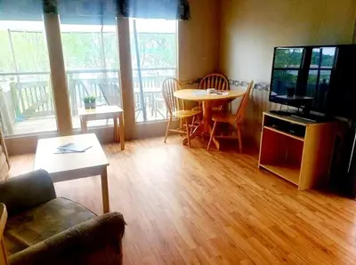 a living room with a couch and a table and a television at Westlake Dunes View Beach-FREE Pontoon Boat Rental in West Lake
