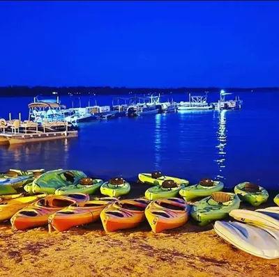 a bunch of kayaks lined up on the beach at Westlake Dunes View Beach-FREE Pontoon Boat Rental in West Lake