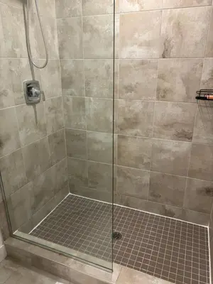 a shower with a glass door and a tile floor at 3 Bdrm Blue Mountain Condo in Collingwood