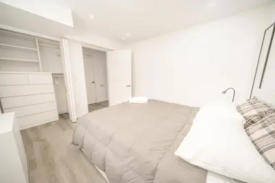 a white bedroom with a large bed and white cabinets at Luxurious 2 Bed Apartment in Downtown Cambridge in Cambridge