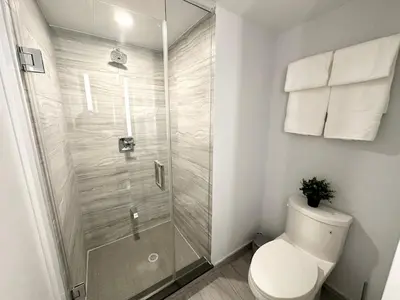 a bathroom with a toilet and a glass shower at Condo in Yorkville - Newly Furnished Luxury Unit in Toronto