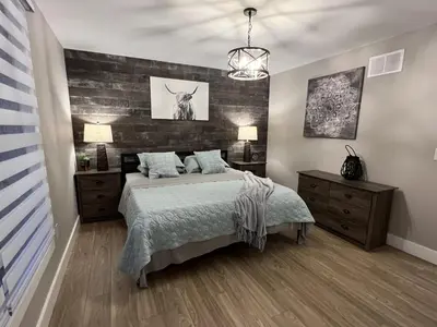a bedroom with a bed and a wooden wall at The Luxe Lodge in Algonquin Highlands