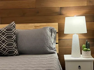 a bedroom with a bed with a lamp on a night stand at The Luxe Lodge in Algonquin Highlands
