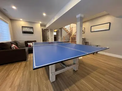 a ping pong table in a living room at The Luxe Lodge in Algonquin Highlands