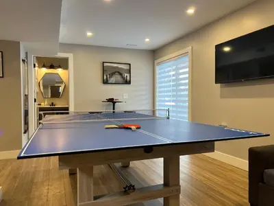 a ping pong table in a living room with a ping pong ball at The Luxe Lodge in Algonquin Highlands