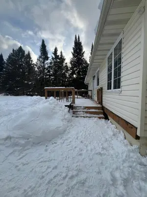 a house with a pile of snow in front of it at The Luxe Lodge in Algonquin Highlands