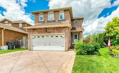 a brick house with a garage in the yard at Luxury Modern Retreat with Sauna & Modern Amenities in Mississauga