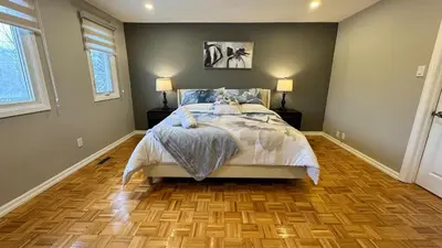 a bedroom with a bed and a wooden floor at Luxury Modern Retreat with Sauna & Modern Amenities in Mississauga
