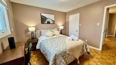 a bedroom with a bed and a desk with two lamps at Luxury Modern Retreat with Sauna & Modern Amenities in Mississauga
