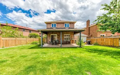 a home with a wooden fence and a yard at Luxury Modern Retreat with Sauna & Modern Amenities in Mississauga