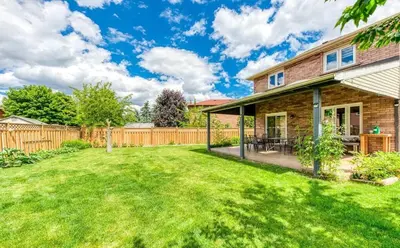 a backyard with a wooden fence and a house at Luxury Modern Retreat with Sauna & Modern Amenities in Mississauga