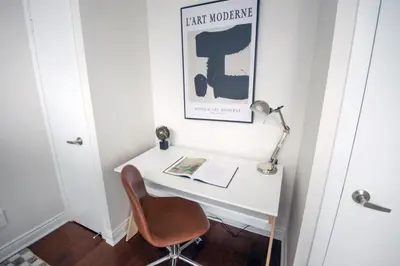 a white desk with a chair and a lamp at 3BR Urban Gem with Scenic Balcony Views in Toronto