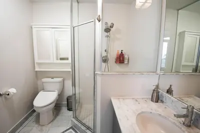 a bathroom with a toilet and a sink and a shower at 3BR Urban Gem with Scenic Balcony Views in Toronto