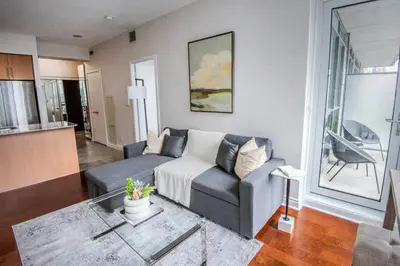 a living room with a couch and a table at 3BR Urban Gem with Scenic Balcony Views in Toronto