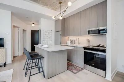 a kitchen with a counter and a bar with a stool at Studio Gem in the lovely Waterfront Communities in Toronto