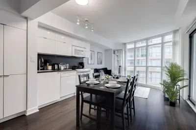 a kitchen and dining room with a table and chairs at Exquisitely Furnished 1BR Suite in DWTN Toronto in Toronto