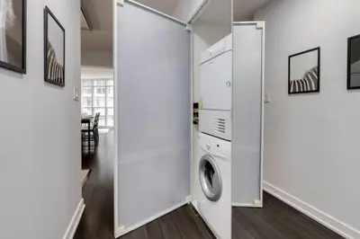 a laundry room with a washer and dryer at Exquisitely Furnished 1BR Suite in DWTN Toronto in Toronto