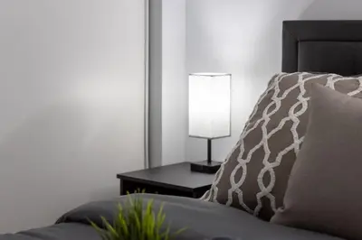 a lamp sitting on a table next to a bed at Exquisitely Furnished 1BR Suite in DWTN Toronto in Toronto