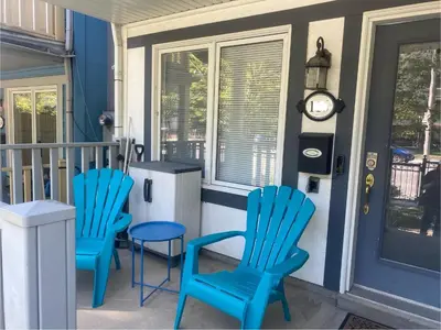 a porch with two blue chairs and a clock at Toronto downtown Woodbine beaches private cozy room in Toronto