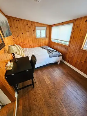 a bedroom with a bed and a desk in a room at Spacious 2-bedroom ground floor unit near beach in Cobourg