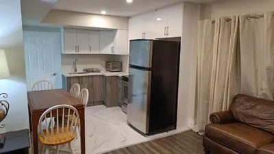 a kitchen with a refrigerator and a table and a couch at Garden View in Schomberg