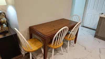 a wooden table with four chairs in a kitchen at Garden View in Schomberg