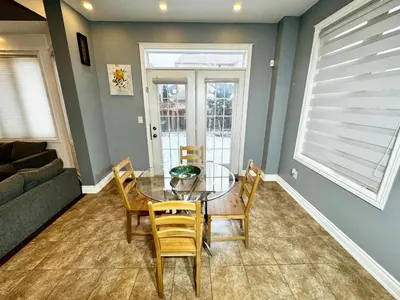 a dining room with a glass table and chairs at 3500 SqFt - Modern and Comfort - 4 BDRM Getaway - Relax - Unwind - Explore - Near Airport & Toronto Downtown in Brampton