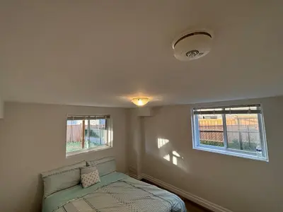 a bedroom with a bed and two windows at One-Bedroom Unit at VISTA HILL in Waterloo