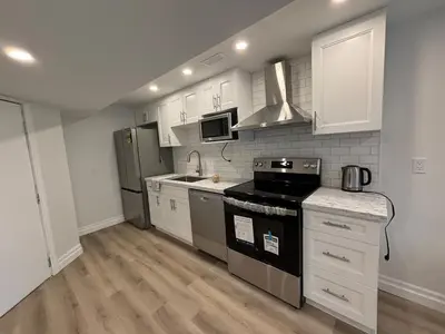 a kitchen with white cabinets and black appliances at One-Bedroom Unit at VISTA HILL in Waterloo