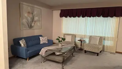 a living room with a blue couch and chairs at Welcome to our cozy private Home in Pickering