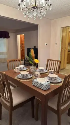 a wooden table with chairs and a dining room at Welcome to our cozy private Home in Pickering
