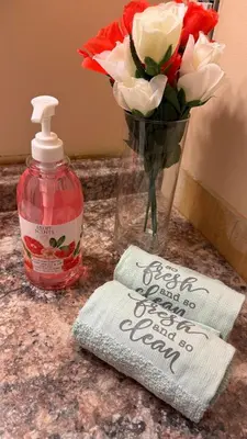 a vase of flowers and a bottle of soap at Welcome to our cozy private Home in Pickering