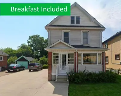 a house with a front porch with the words breakfast included at Ultra Close to Clifton Hill and the Falls & Wonderful Free Breakfast Delivered Daily in Niagara Falls