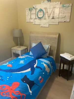 a bedroom with a bed with an octopus bedspread at Ultra Close to Clifton Hill and the Falls & Wonderful Free Breakfast Delivered Daily in Niagara Falls