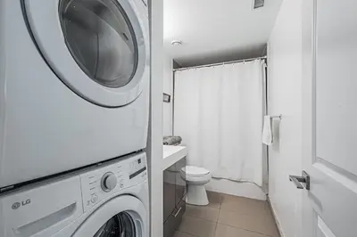 a bathroom with a washing machine and a toilet at 2BR Condo close to Eaton Center in Toronto