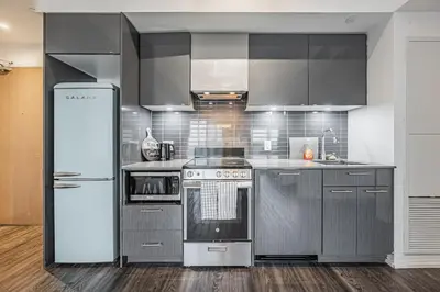 a kitchen with stainless steel appliances and a refrigerator at 2BR Condo close to Eaton Center in Toronto