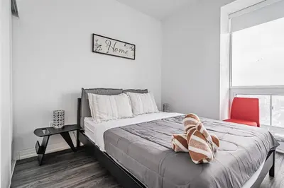 a bedroom with a bed and a red chair at 2BR Condo close to Eaton Center in Toronto