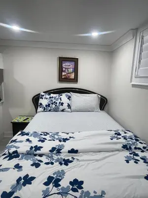 a bedroom with a bed with blue flowers on it at Luxury Basement-Private Bdr & Bathroom with free parking In Toronto in Toronto