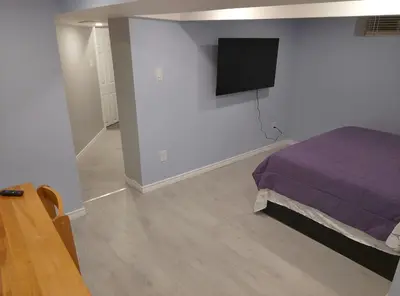 a bedroom with a bed and a flat screen tv at Midtown Toronto suite in Toronto