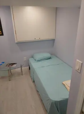 a small room with two beds and a cabinet at Midtown Toronto suite in Toronto